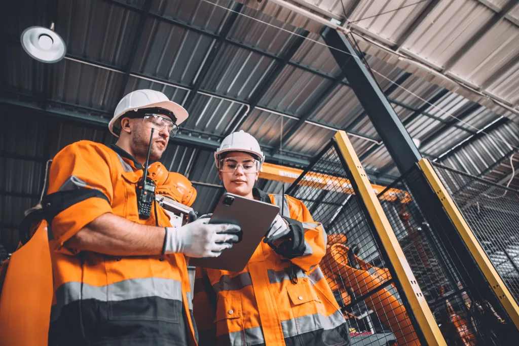 Ingenieur Team Service Roboter Schweißen arbeiten in der Automatisierung Fabrik. Menschen Arbeiter in Sicherheitsanzug Arbeit Roboterarm Software-Programmierung oder Ersetzen von Teil in automatisierten Fertigungsindustrie Technologie.